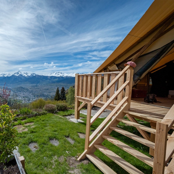 Luxury canvas tent with triple roof for natural ventilation.